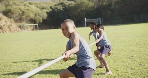 Joyful Boys Engaged in Competitive Outdoor Tug of War Activity