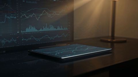Sleek tablet with online trading financial charts in modern workspace