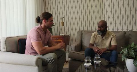 Two men in deep conversation in cozy living room