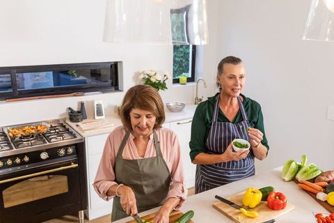 Senior Women Enjoying Cooking in Modern Home Kitchen
