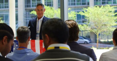 Male Speaker Presenting at Business Seminar with Attendees Focused