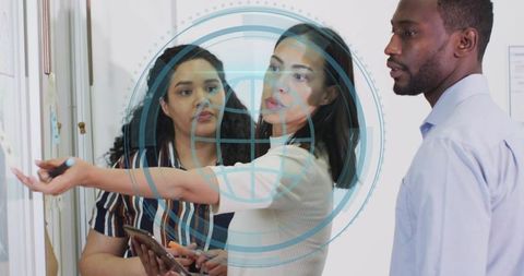 Team collaborating at glass board with ar overlay, pointing and presenting tablet data