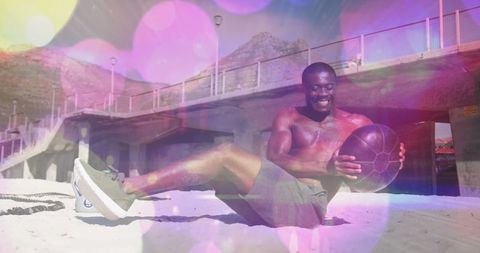 Fit Man Exercising with Medicine Ball on Beach with Light Effects