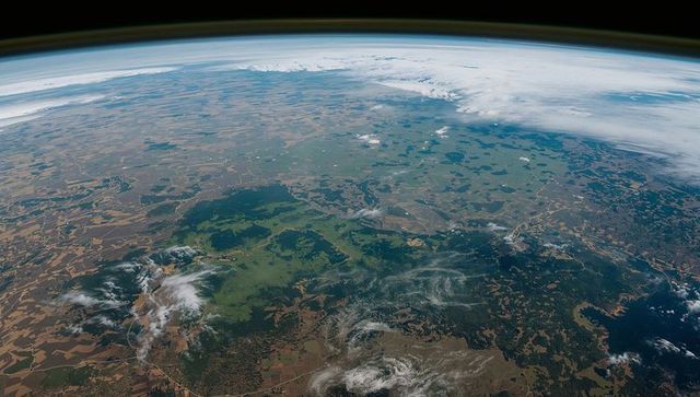 Stunning low earth orbit view of farmland and clouds