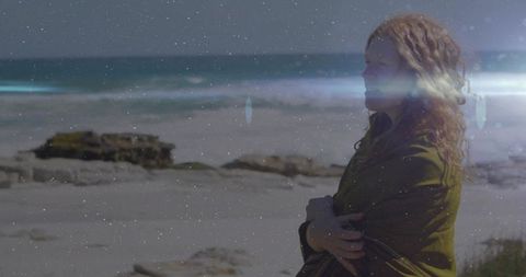 Woman in green shawl gazing at idyllic seascape with calm waves