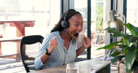 Young woman cheering in office celebrating success