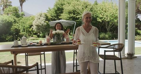 Women Celebrating Garden Party with Drinks and Desserts