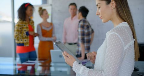 Businesswoman Using Tablet in Dynamic Office Environment