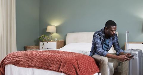 Traveler Relaxing in Modern Hotel Room Checking Smartphone