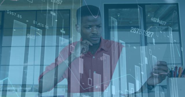 Image of financial graphs and data over african american man in office. Business, finance, economy, data processing and technology concept digitally generated image.