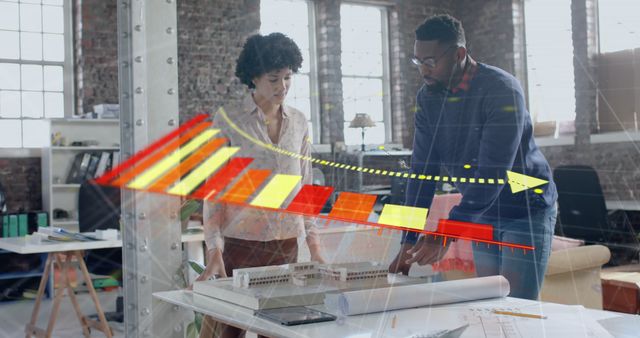 Professionals engaging in collaborative discussion over architectural plans, accompanied by a transposed digital growth chart. Ideal for illustrating themes like business strategy, collaboration, innovation, and modern workflow in office environments. Suitable for articles on teamwork, architectural design, project planning, and technological integration in professional workspaces.