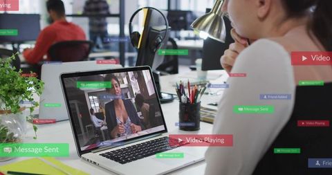 Watching Video Call on Laptop at Busy Office Desk with Social Notifications Overlay