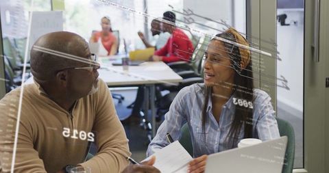 Diverse Office Team Brainstorming Innovative Projects on Laptops