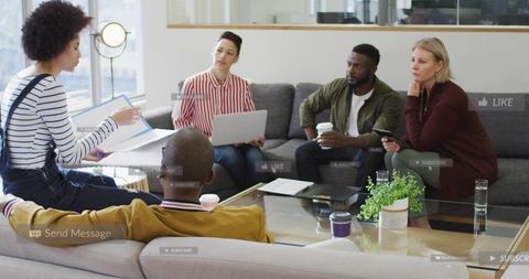 Presenting woman leading creative meeting in modern office lounge with diverse team