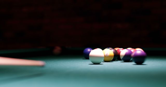 Abstract, focused lighting captures the tension and focus of a billiard game in a dimly lit environment. Ideal for advertisements, sports publications, or game room decor showcasing leisure activities or indoor sports.