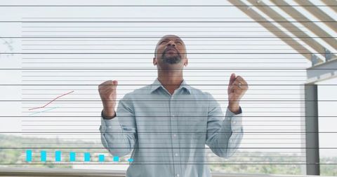 Business leader celebrating success while raising hands on balcony with analytics overlay