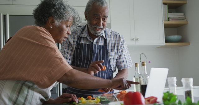 Happy african american senior couple cooking and talking together. healthy, active retirement lifestyle at home.