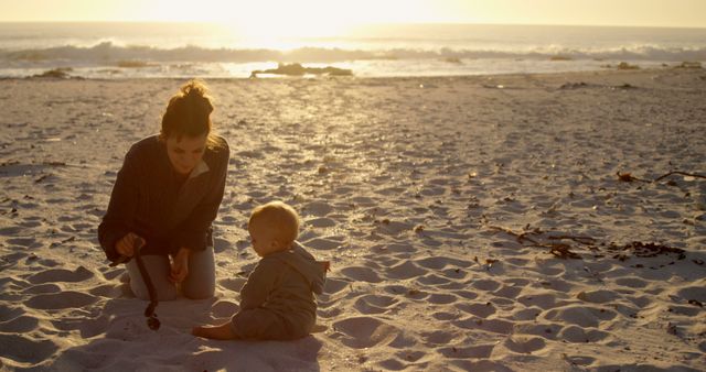 Mother and child playing in sand at sunset beach - Download Free Stock Images Pikwizard.com