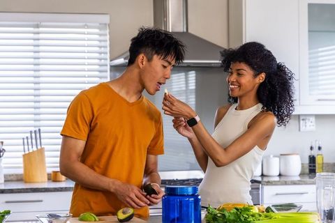 Diverse couple preparing healthy avocado meal in bright modern kitchen morning routine