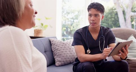 Young Physiotherapist Discussing Treatment with Elderly Patient