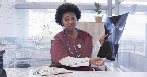 Clinician holding x-ray pointing with pen explaining orthopedic diagnosis with data