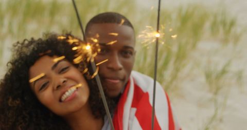 Happy Couple Celebrating with Sparklers on Sandy Beach