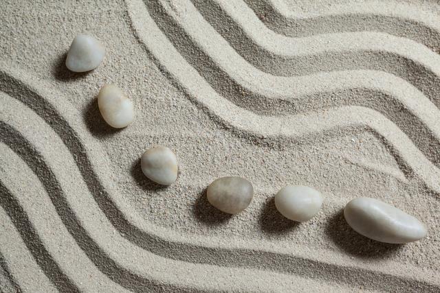 White Pebble Stones Arranged on Wavy Sand Pattern - Download Free Stock Photos Pikwizard.com