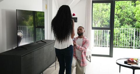 Man proposing at home with romantic gesture