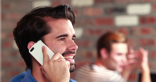 Smiling Man Having Phone Conversation in Brick-Walled Cafe - Download Free Stock Images Pikwizard.com