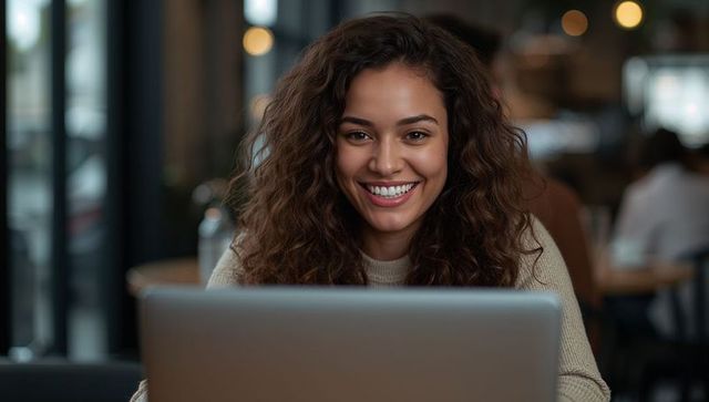 Smiling Woman Working on Laptop in Cozy Cafe Interior