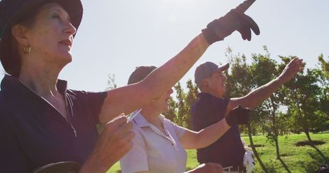 Seniors Enjoying Golf on Sunny Day Pointing in the Direction