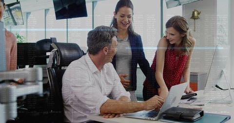 Team Collaborating Around Laptop in Modern Office, Discussing Project Plans and Strategy