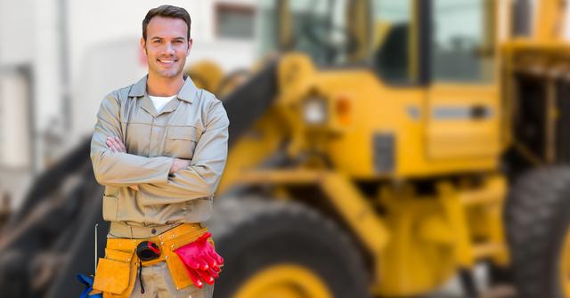 A confident construction worker is smiling with arms crossed, wearing a tool belt and gloves in front of construction machinery. Suitable for use in industries related to construction, heavy machinery, labor workforce, safety protocols, and team management imagery.