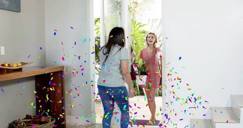 Surprise welcome guest arriving with potted plant and confetti at home entryway