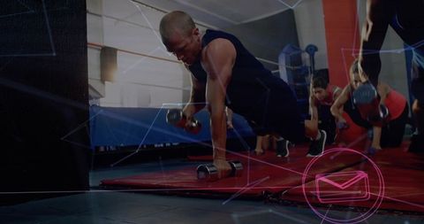 Man performing dumbbell plank rows in group workout studio with neon overlay