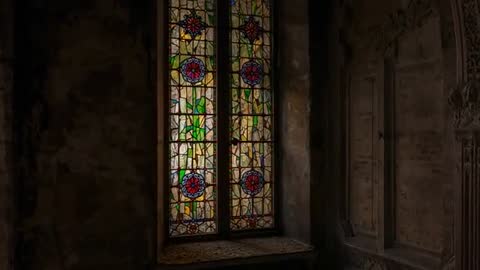 Light streaming through stained glass window in abandoned chapel