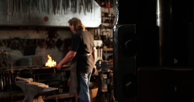 Blacksmith Working in Dimly Lit Workshop with Glowing Forge - Download Free Stock Images Pikwizard.com