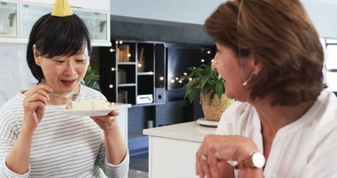 Senior Friends Enjoying Birthday Cake in Cozy Kitchen Celebration