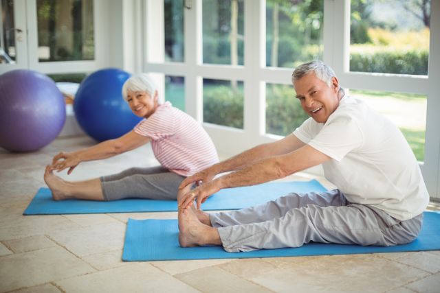 Senior couple performing stretching exercise on exercise mat at home