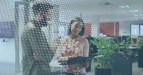 Professional teamwork behind dotted glass in modern office