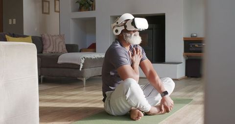 Relaxed senior man meditating with vr headset in modern living room