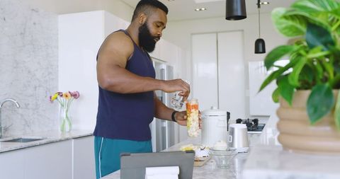 Man Preparing Healthy Smoothie with Fresh Fruits in Modern Kitchen