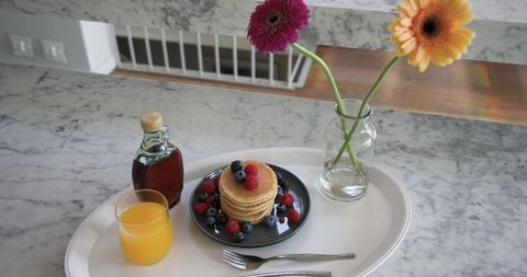 Minimalistic Breakfast Display with Pancakes and Fresh Berries on Marble Countertop