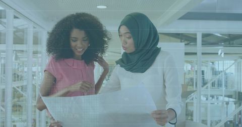 Businesswomen Collaborating on Financial Plans in Modern Office