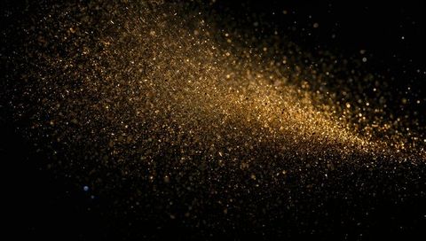 Shimmering Gold Dust Cloud Sweeping Across Black Background with Diagonal Sparkle Trail