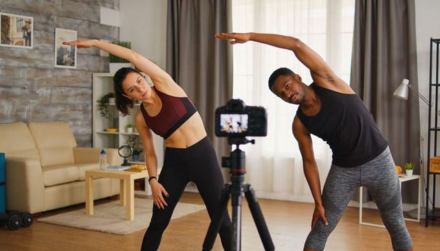 Fitness couple filming home workout stretching side bends for mobility and balance