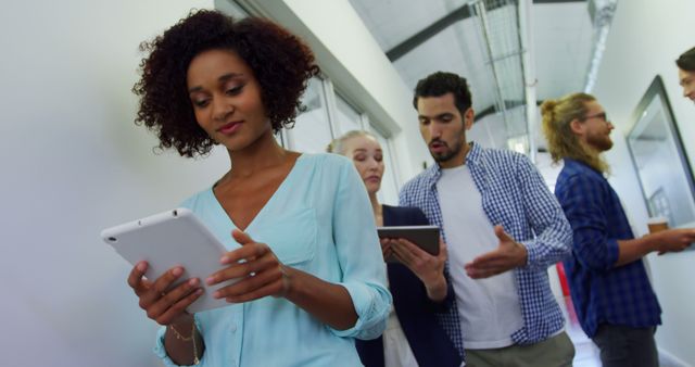 Coworkers Using Tablets and Discussing Project in Office Hallway - Download Free Stock Images Pikwizard.com