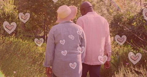 Senior Couple Strolling Through Garden with Heart Motifs
