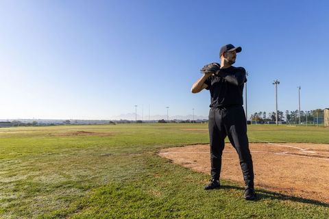 Baseball Pitcher Preparing Throw at Home Plate on Sunny Field with Wide Copy Space