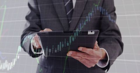 Businessman Holding Tablet Analyzing Stock Market Candlestick Chart Overlay